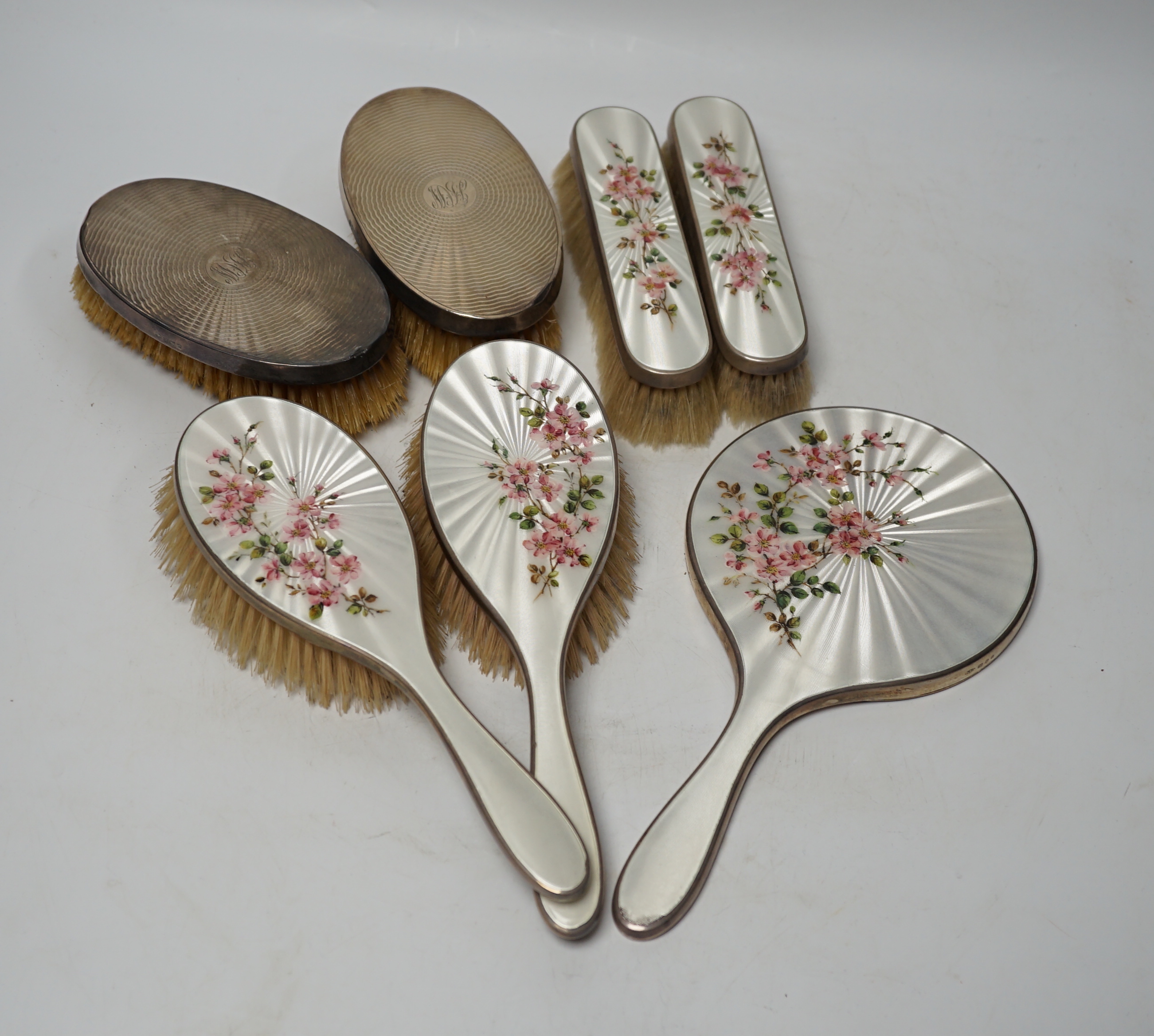 A George VI five piece silver and enamel mounted mirror and brush set, London, 1941 and a pair of silver mounted clothes brushes.